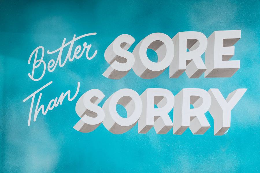 A mural reading Better Sore Than Sorry